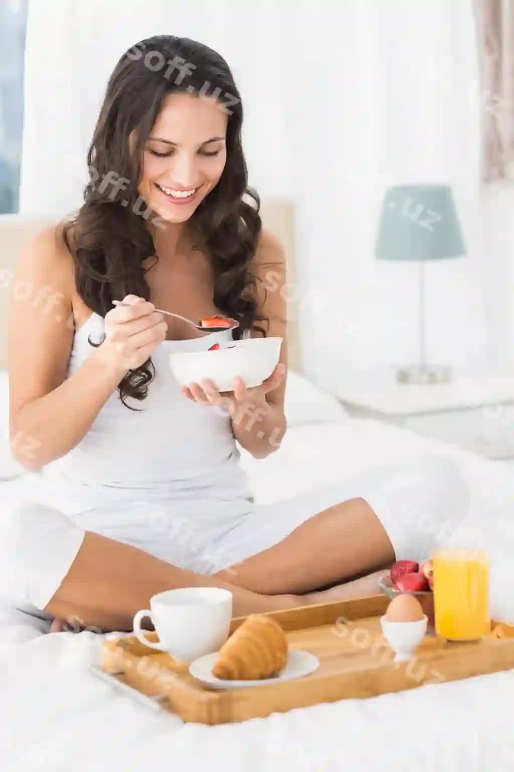 Baxtli qora sochli karavonida nonushta qilmoqda. | Happy brunette having breakfast bed