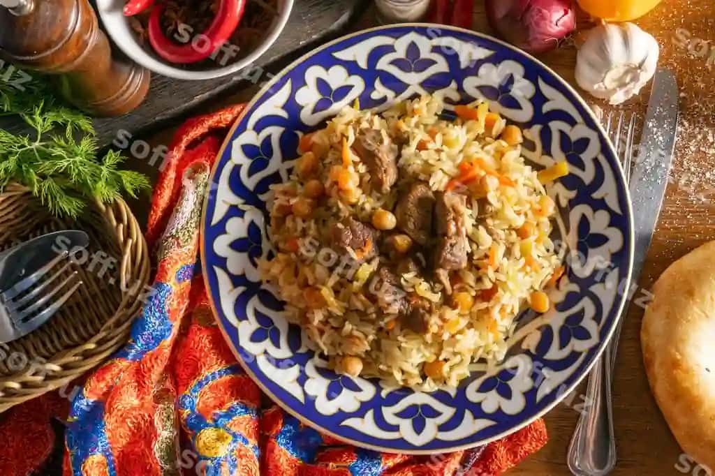 Qazi palov, an'iy sharqiy issiq taom, guruch, qazi, sariq morcha, sarimsoq, kishmish, nohat, zirvak, milliy o'zbek naqshi bilan disk. | Pilaf with lamb traditional oriental hot dish rice lamb yellow carrots with garlic raisins chickpeas turmeric plate with national uzbek ornament