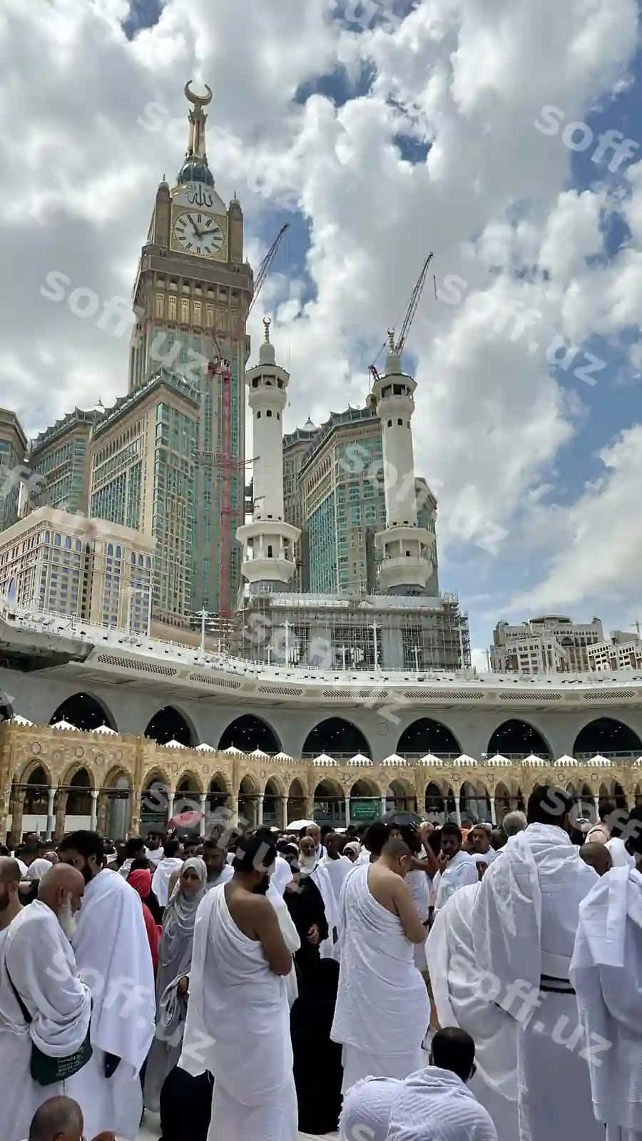 Guruh odamlar katta minora orqa fonda binoning atrofida yig'ilgan. | Group people are gathered around building with large tower background