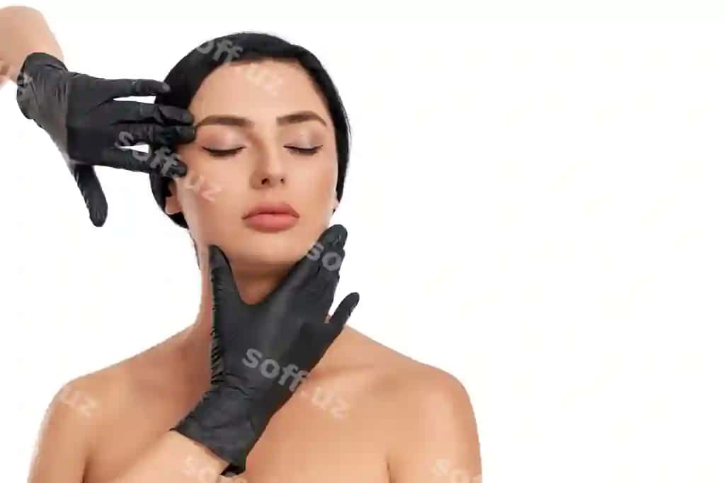 Chiroyli yosh qora sochli ayol sog' va toza teriga ega, g'ozalik mutaxassis qo'llari bilan poslyatmoqda, qora qoqlarini yer qozoniga o'tkazgan. | Adorable young brunette with healthy pure skin posing with beautician hands black gloves around her face