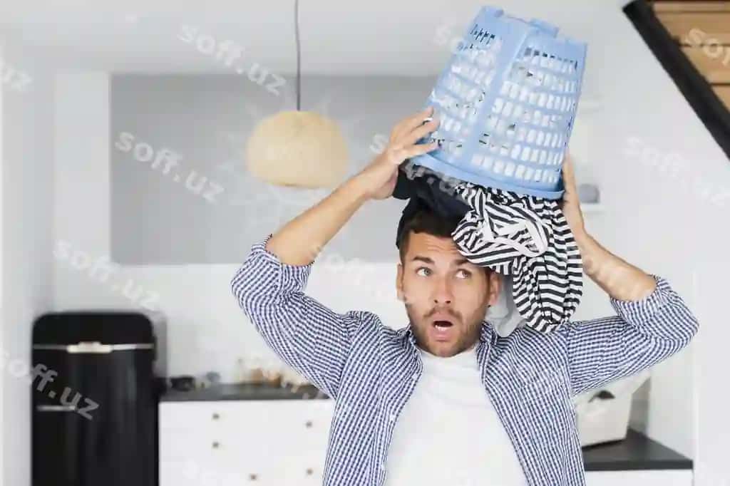 Er boshiga kiyimlar solgan savatni qoymoqda. | Man putting head basket with clothes