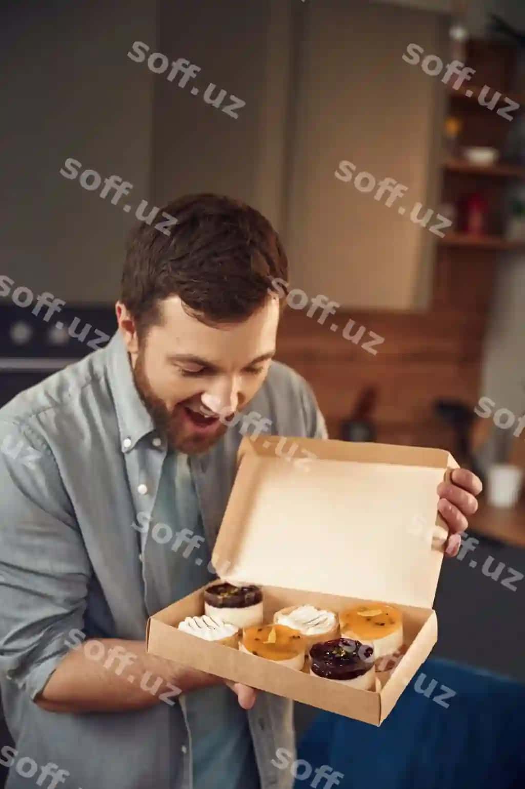 Er mazali dessertdan iborat bo'lgan ekoboxlarda turgan uy ichida. | Man is with delicious desserts that are eco boxes standing indoors