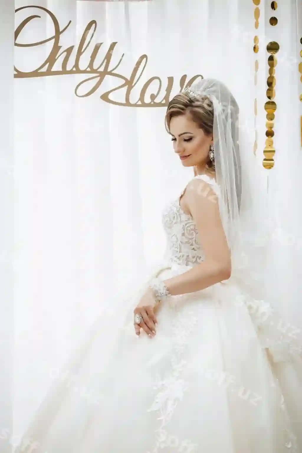 Ayol oq kiyimda faqat sevgi degan belgi oldida turibdi. | Woman white dress is standing front sign that says only love