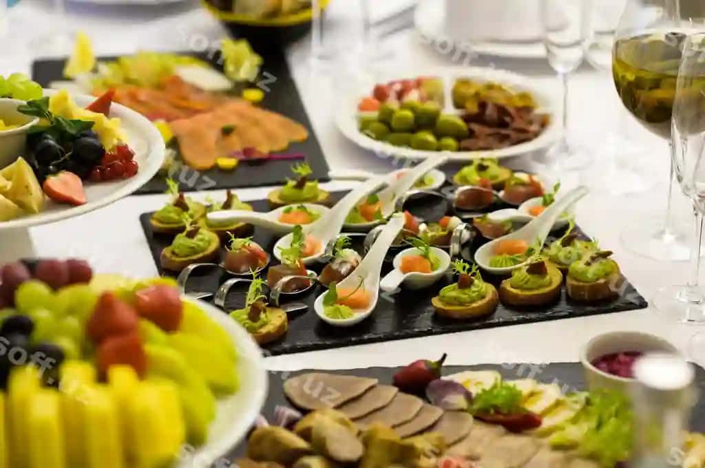 Sovuq sneklar doyalar restoran kafe tadbirkon stoli mazali narsalar qoshiq likop | Cold snacks slices restaurant cafe banquet table with delicacies spoons plates