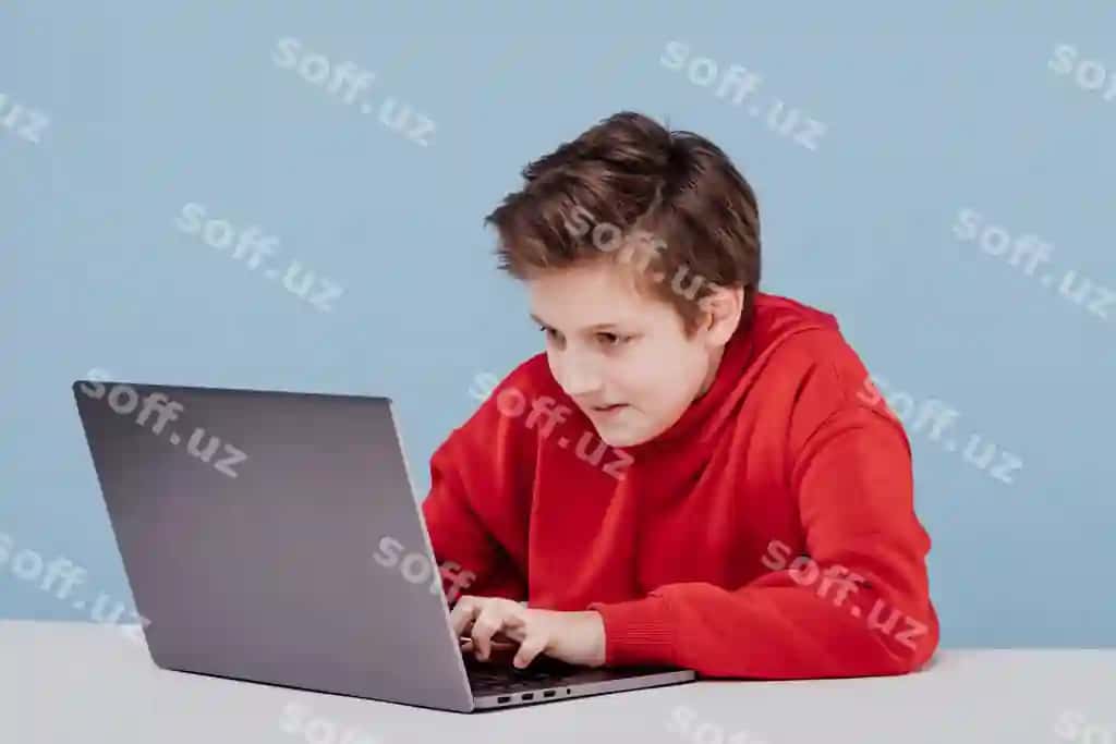Diqqat bilan qizil sviterka o'g'ri noutbukda yozmoqda, studiya ko'k fon. | Concentrated boy red sweatshirt typing laptop studio blue background